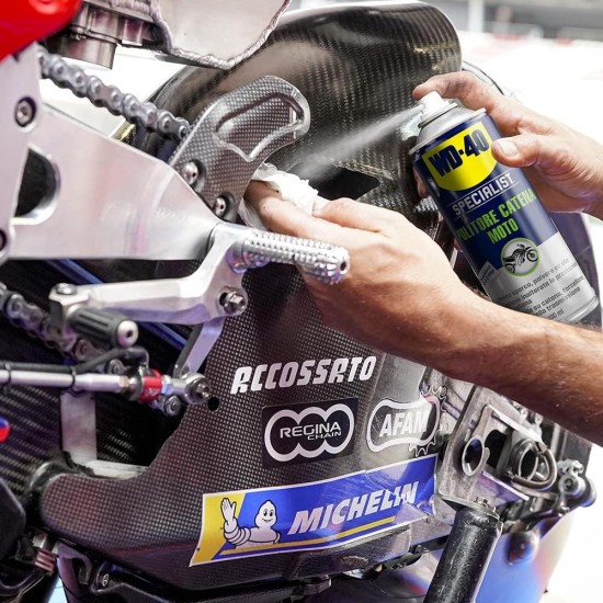 Wd40 Pulitore Catena  mentre viene spruzzato sulla catena e pulita con un fazzoletto bianco