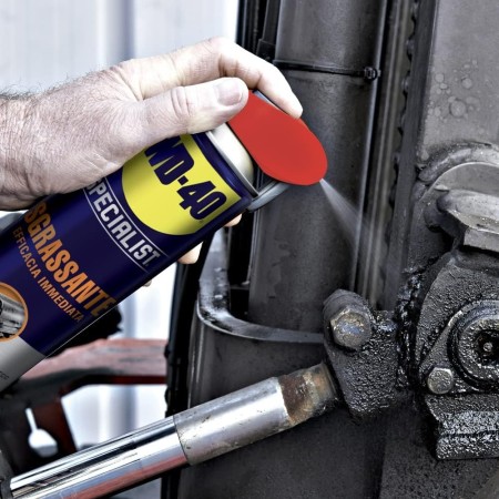 Wd40 Sgrassante Specialist in uso su una cerniera del muletto sporca di grasso