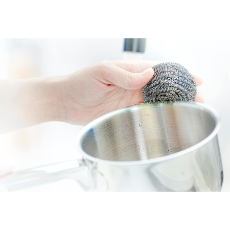 Pagliette in Acciaio Inox mentre puliscono una pentola di acciaio