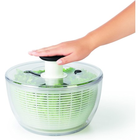 OXO Centrifuga per Insalata con una mano che schiaccia e fa partire la centrifuga