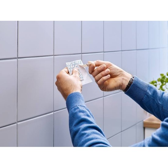 Mani che staccano la pellicola protettiva prima dell'applicazione del Gancetto Adesivo.