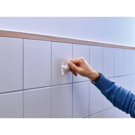 Mano che preme saldamente al muro il Gancio Tesa.